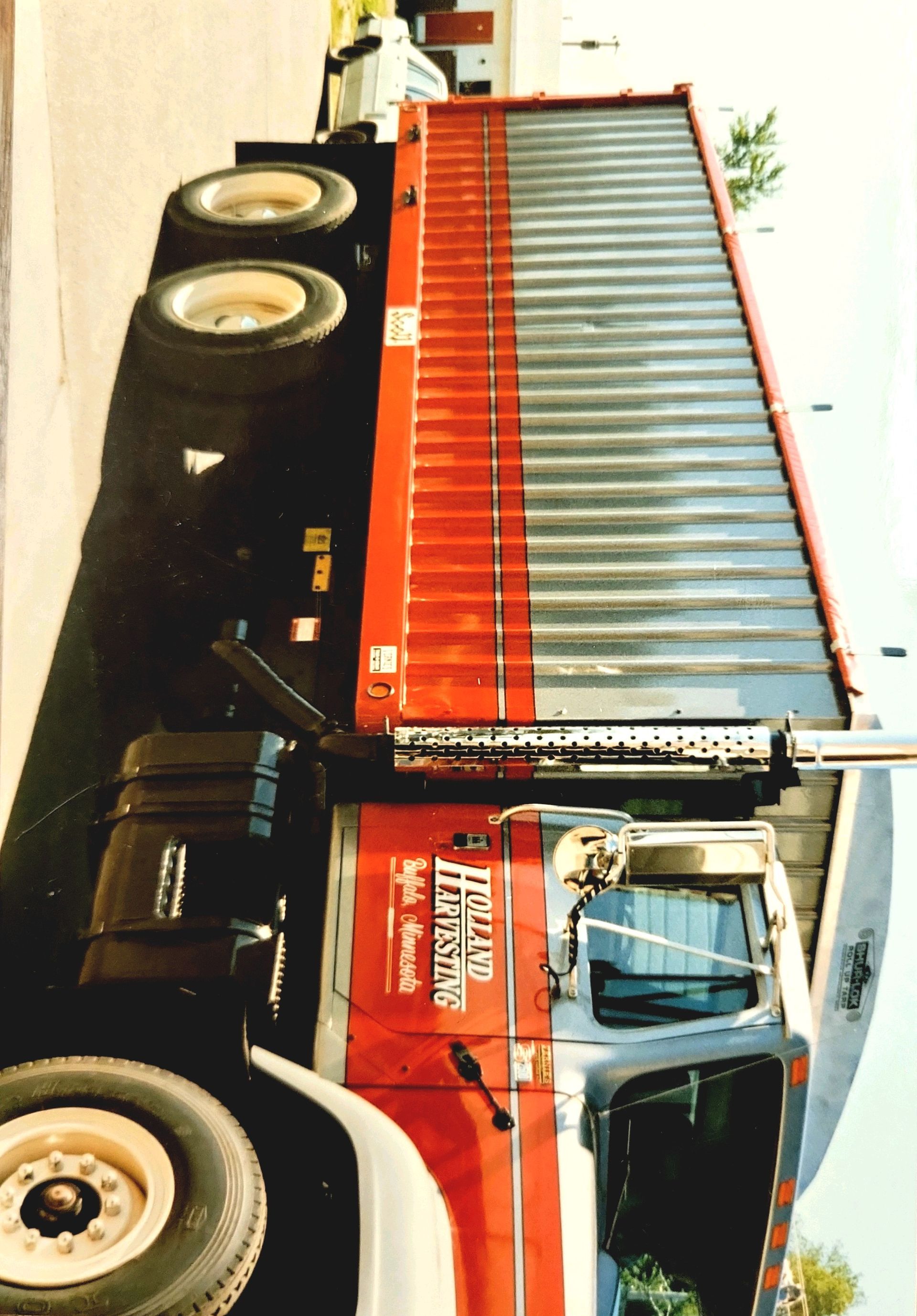A red and black truck with a sign on the side that says heavy hauling