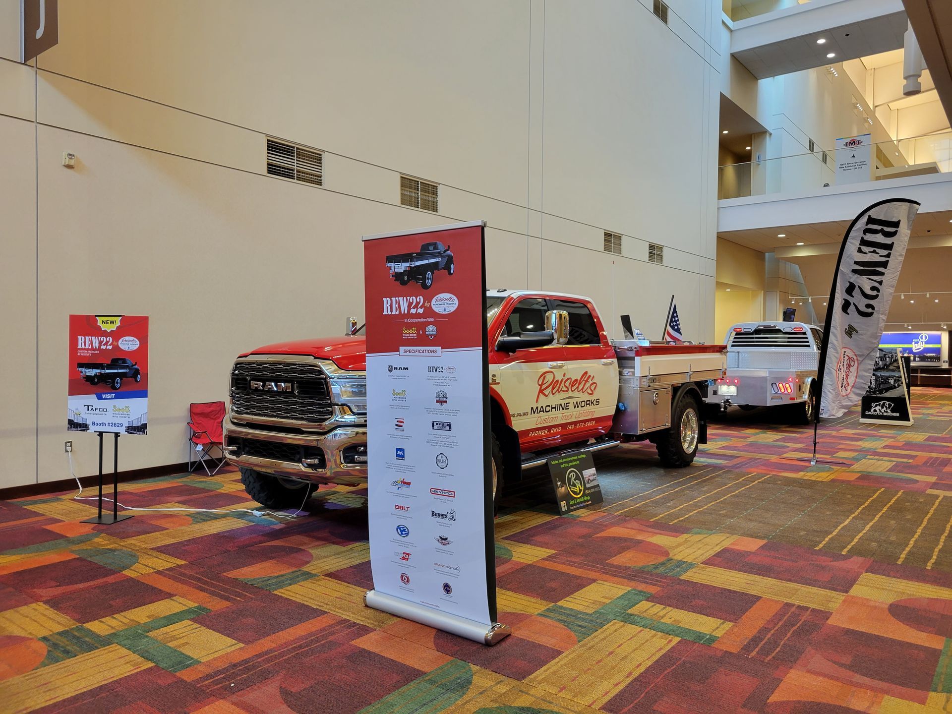 A red truck is parked in a hallway next to a sign.