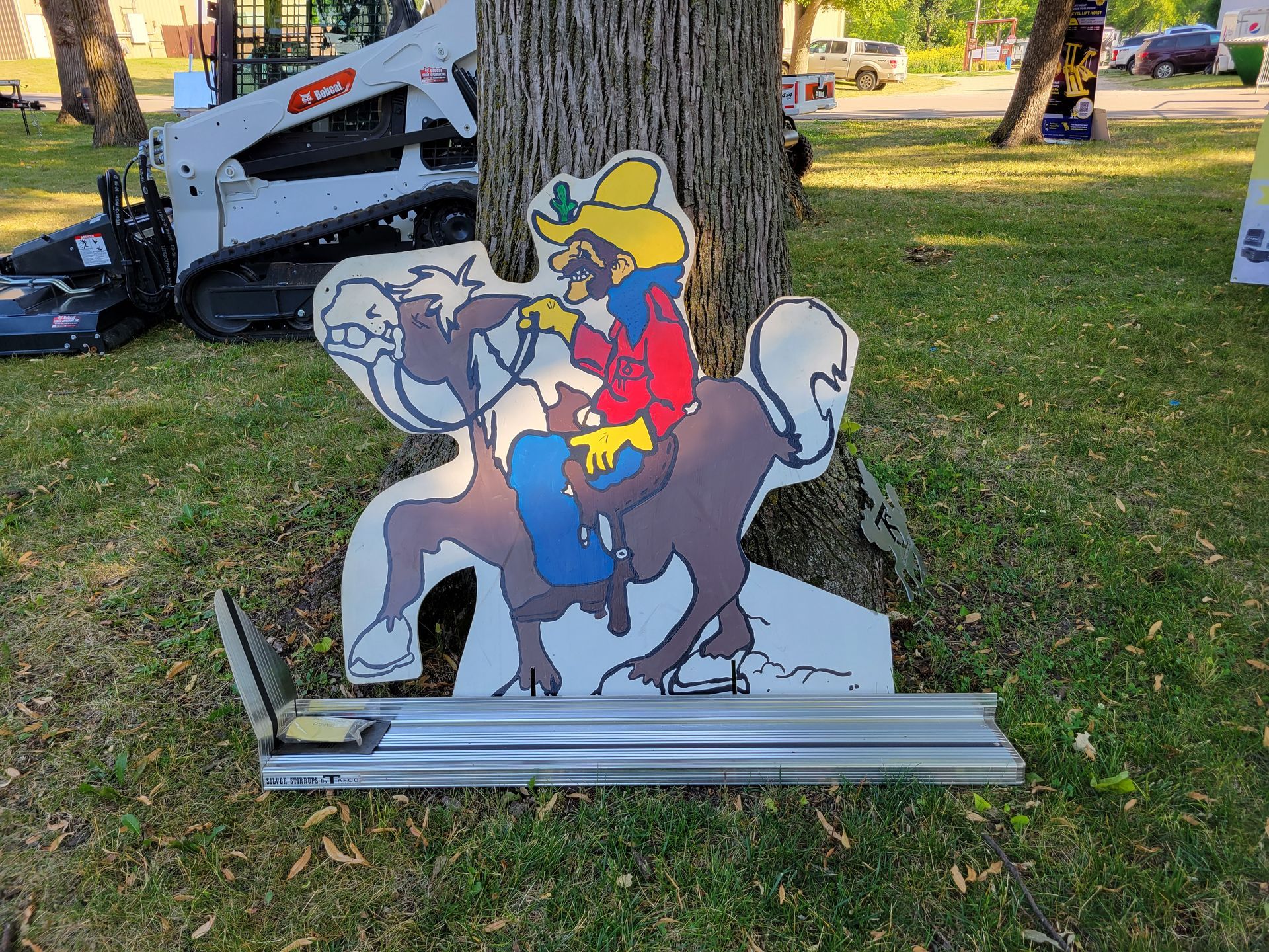 A cardboard cutout of a cowboy riding a horse in a park.