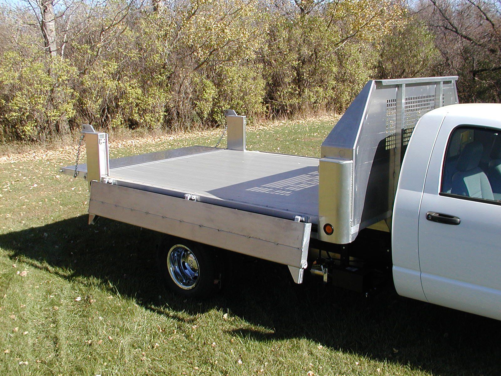 A white truck with a flatbed trailer attached to it