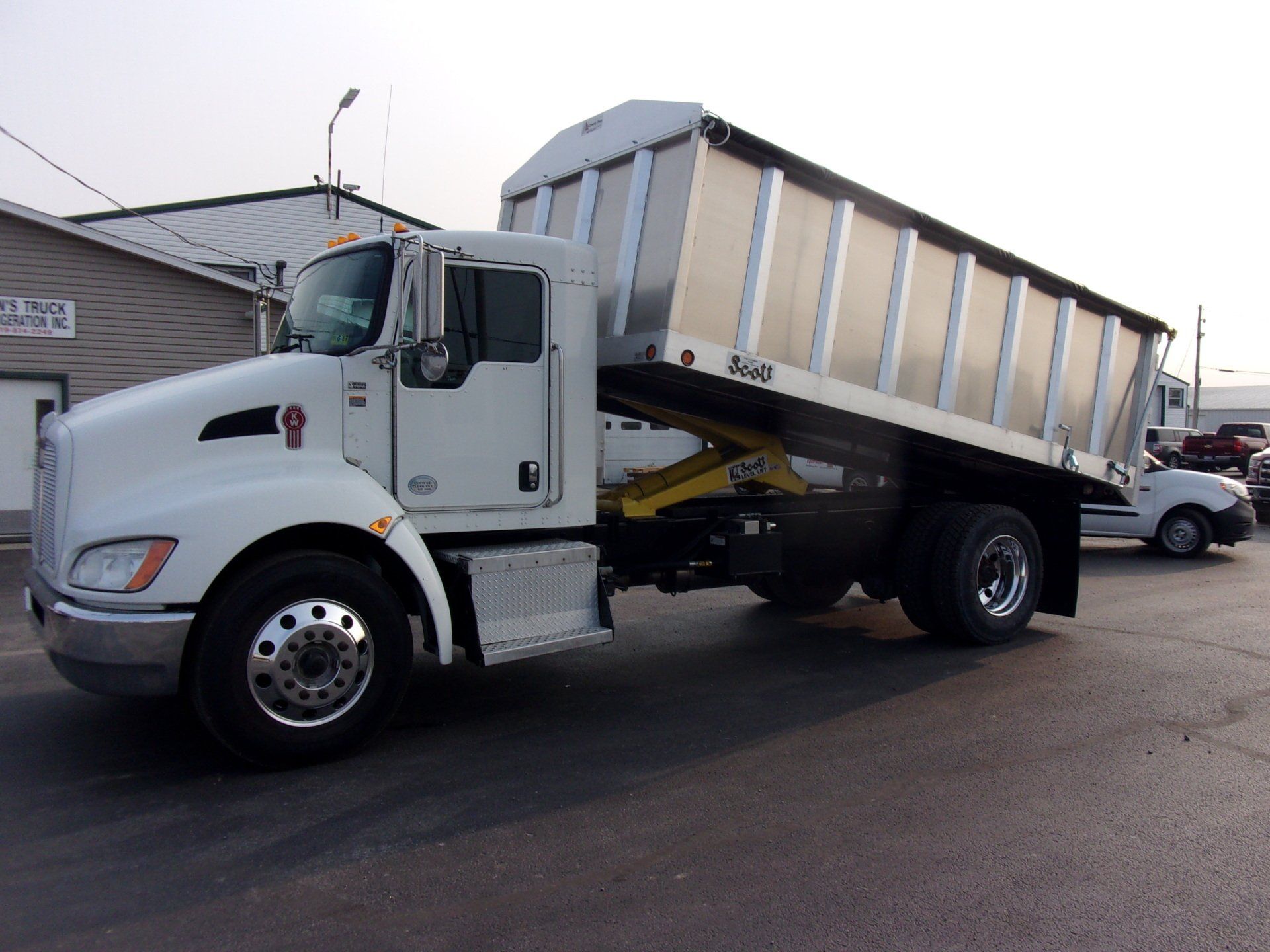 A dump truck is parked in front of a building.