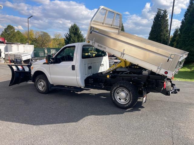 A white dump truck with a snow plow attached to it