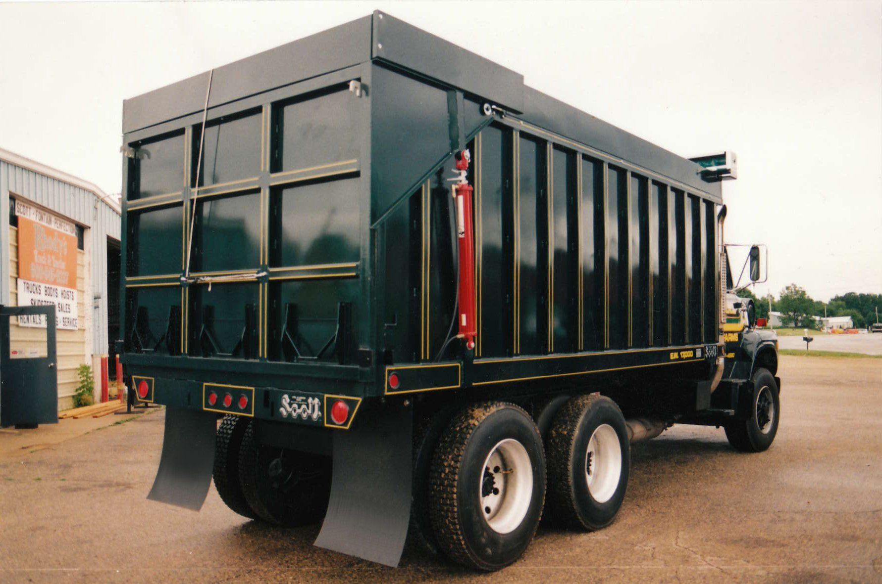 A black dump truck is parked in a parking lot.