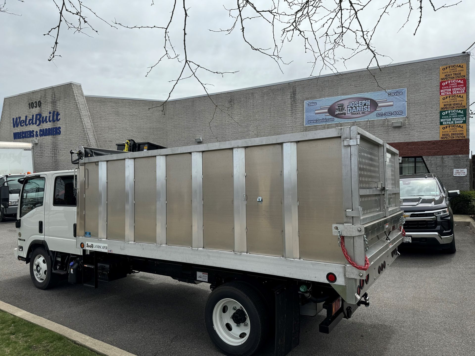 A dump truck is parked in front of a building.