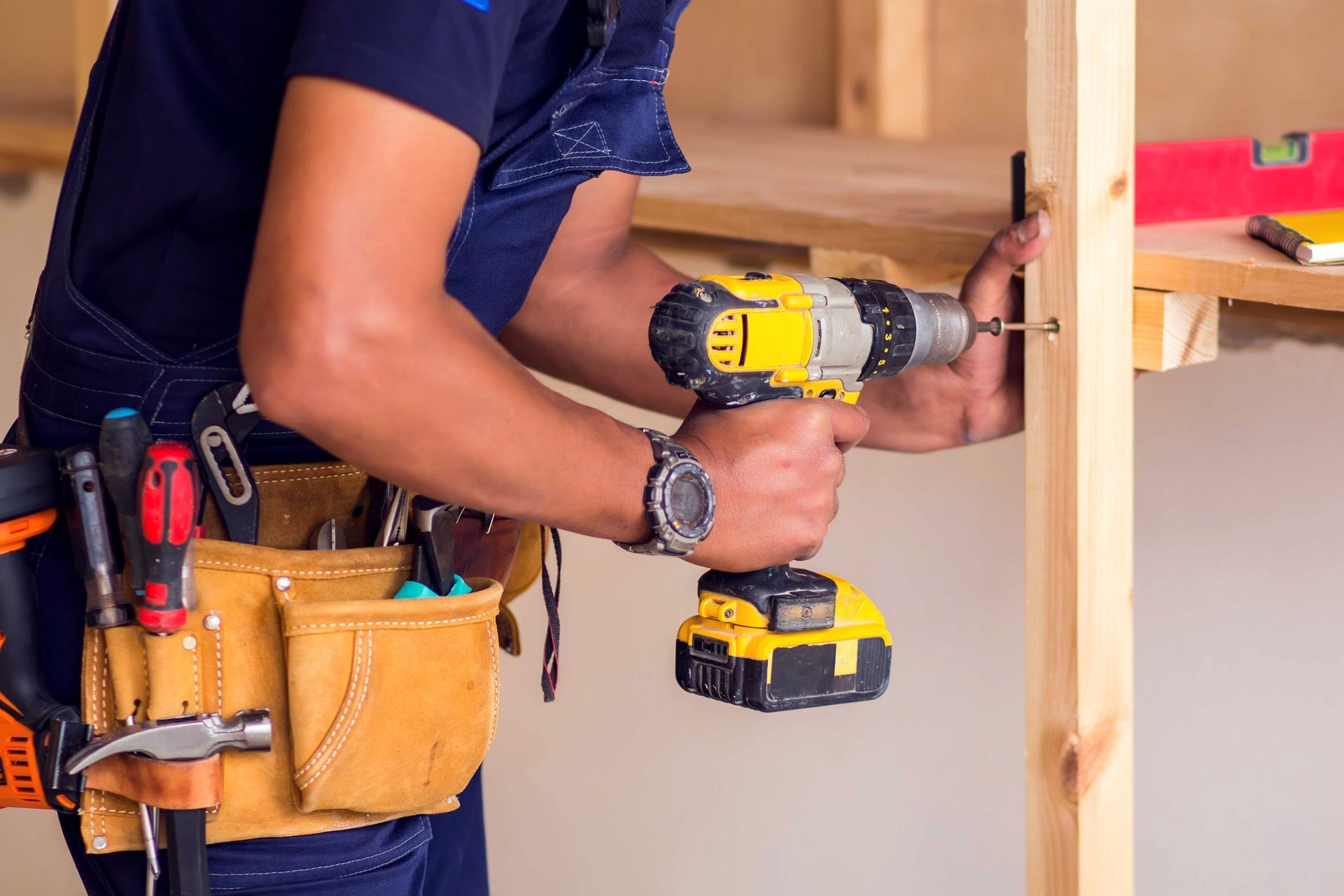 Handyman using drill for repairs, showcasing skilled craftsmanship.