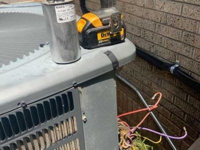A dewalt cordless drill is sitting on top of an air conditioner.