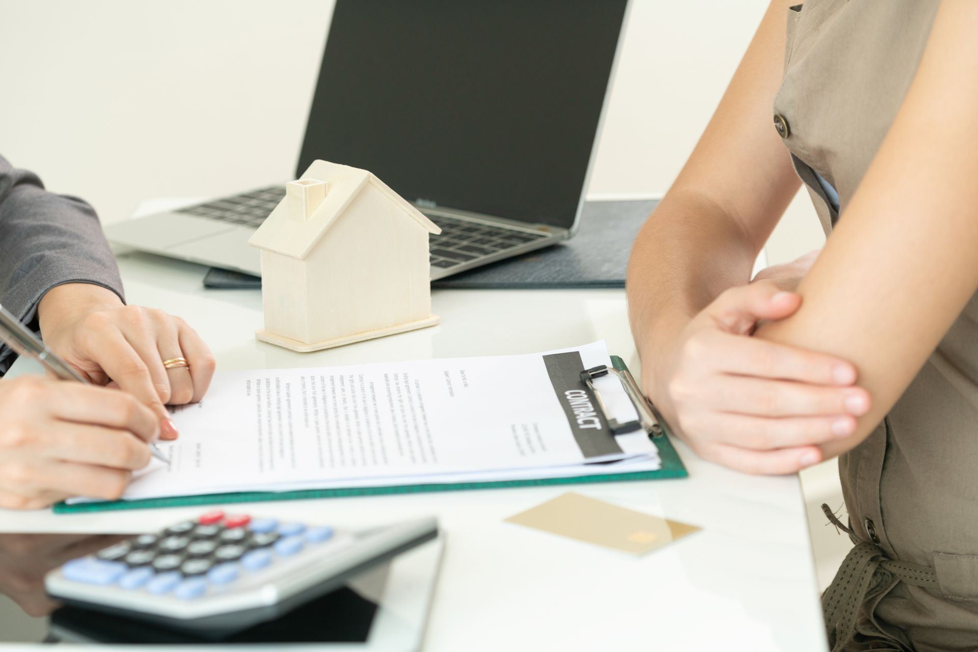 A man and a woman are sitting at a table signing a document.