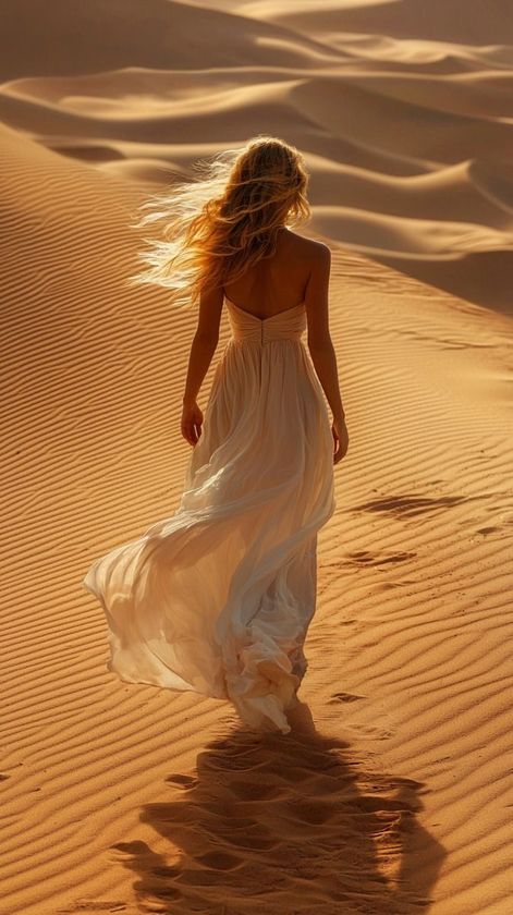 Woman with voluminous, wavy, brown hair, looking down with closed eyes.