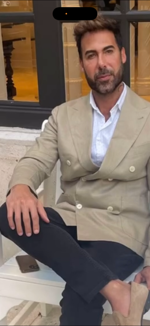 Hands cutting wet, light-brown hair with scissors and a comb against a black backdrop.