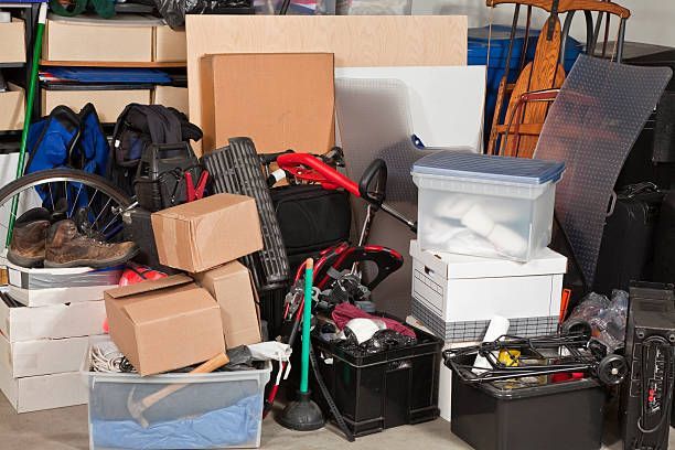 A garage filled with boxes , a bicycle , and other items.