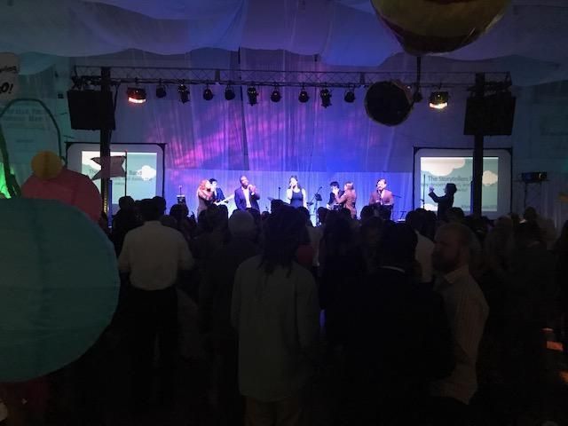 A crowd of people watching a band on stage