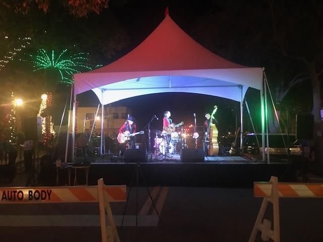 A band is playing on a stage under a white tent