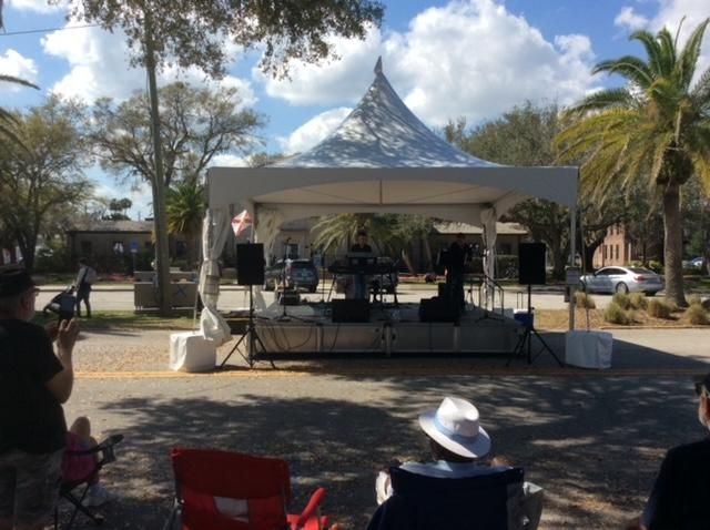 A group of people are sitting in chairs in front of a stage.
