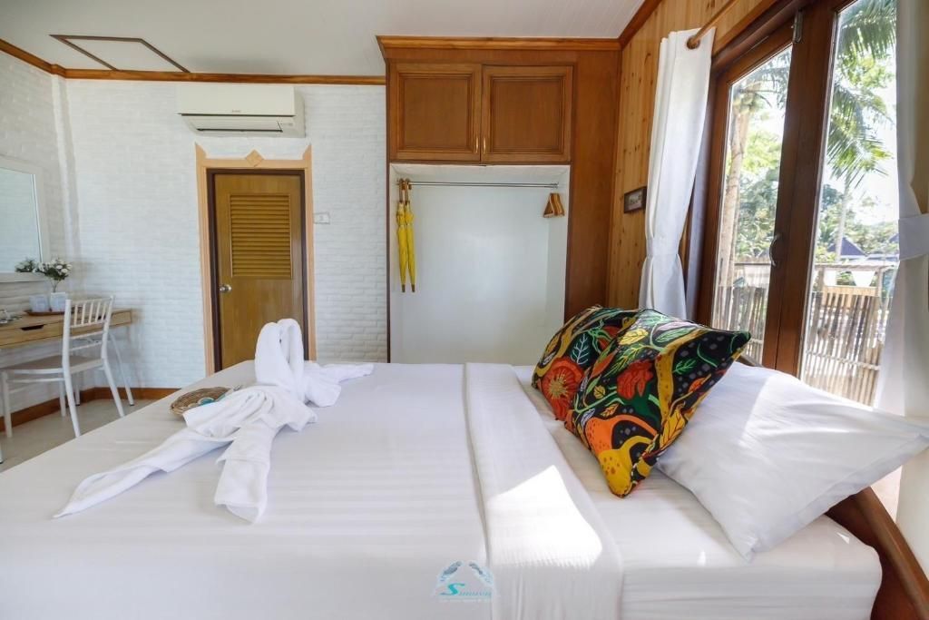 Bedroom with a large bed, wooden furniture, and a window with natural light.