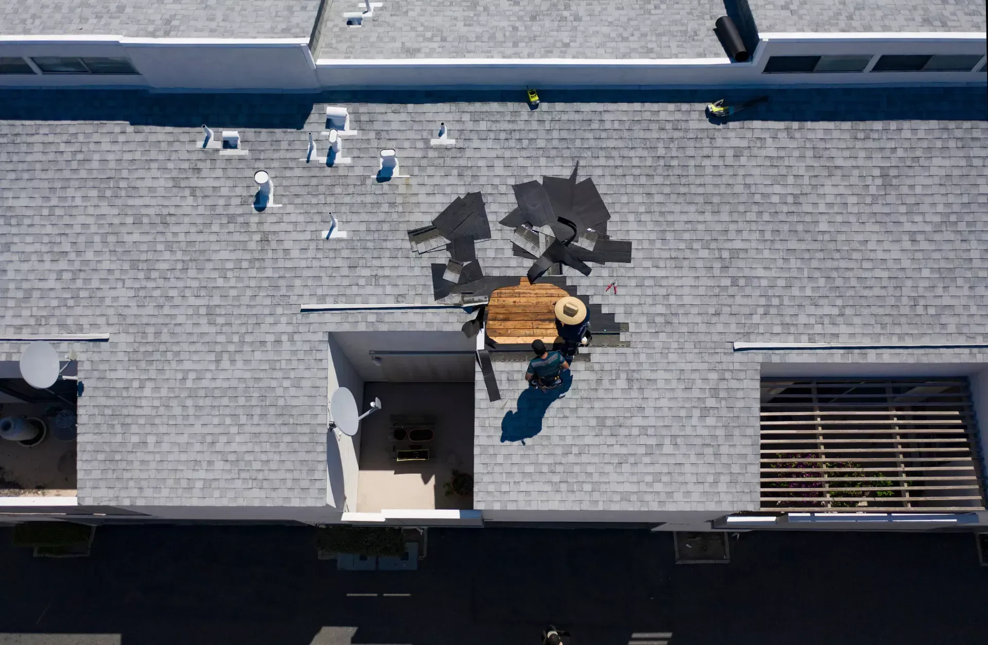 An aerial view of a roof with a table and chairs on it.