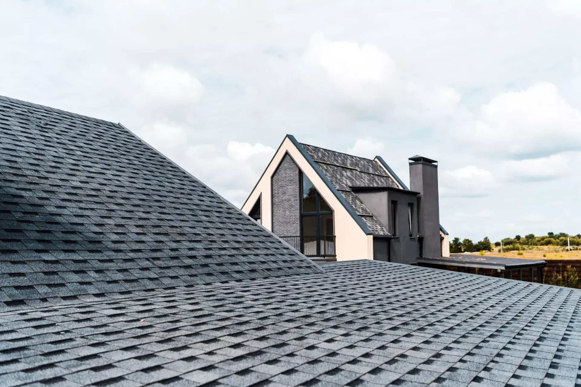 The roof of a house with a gray shingle roof.