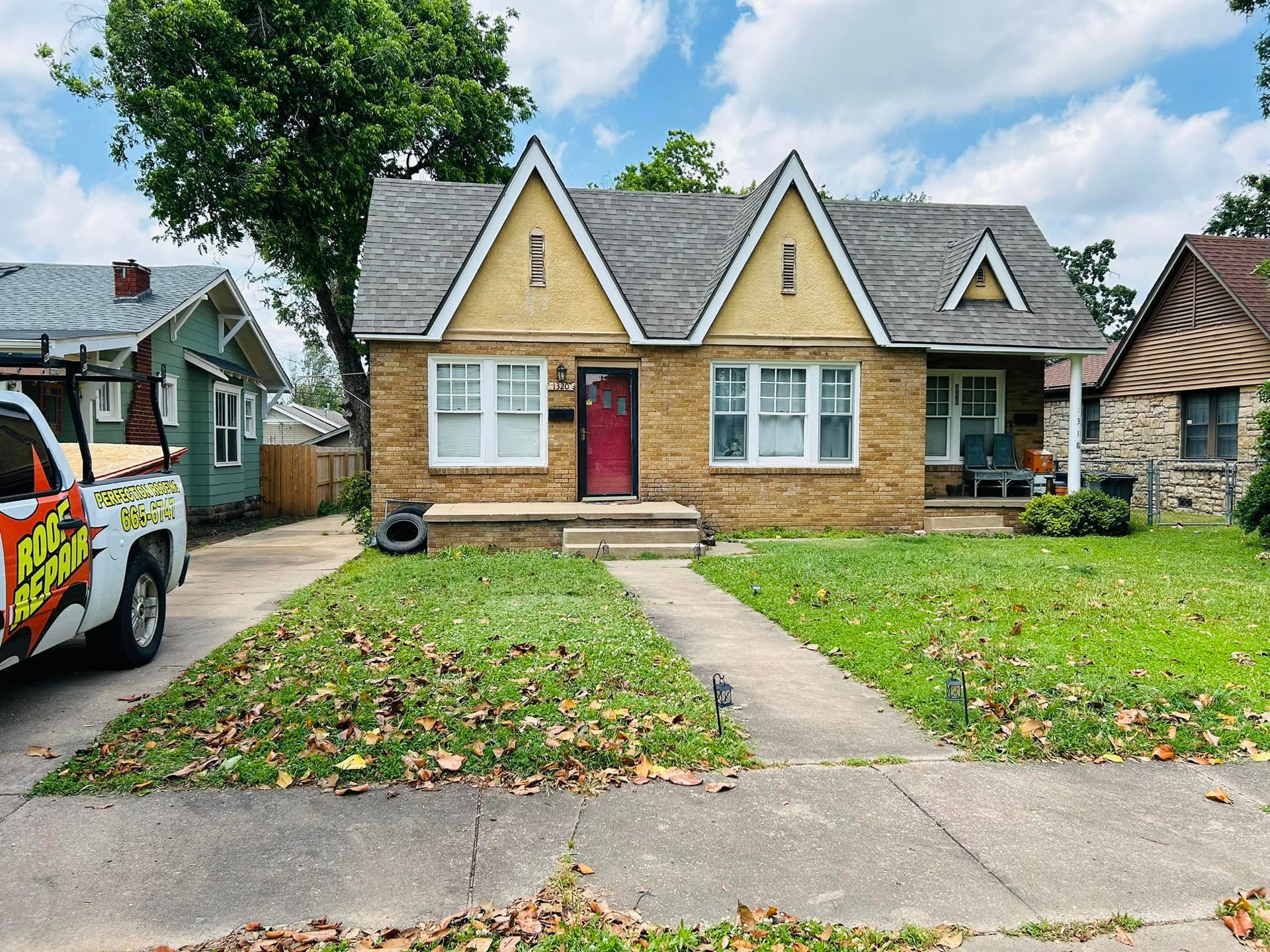 A truck is parked in front of a brick house