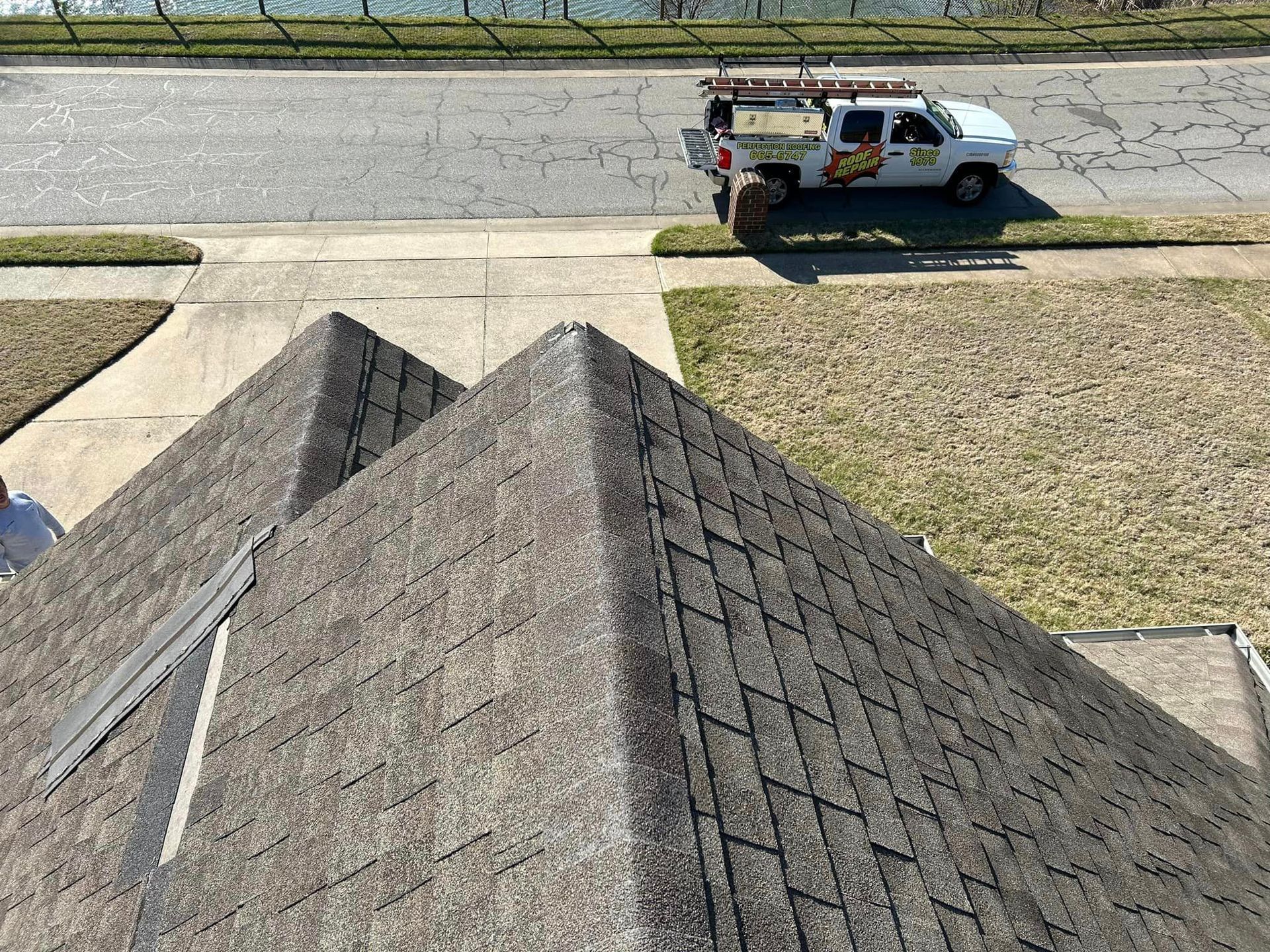 A white truck is parked on the roof of a house.
