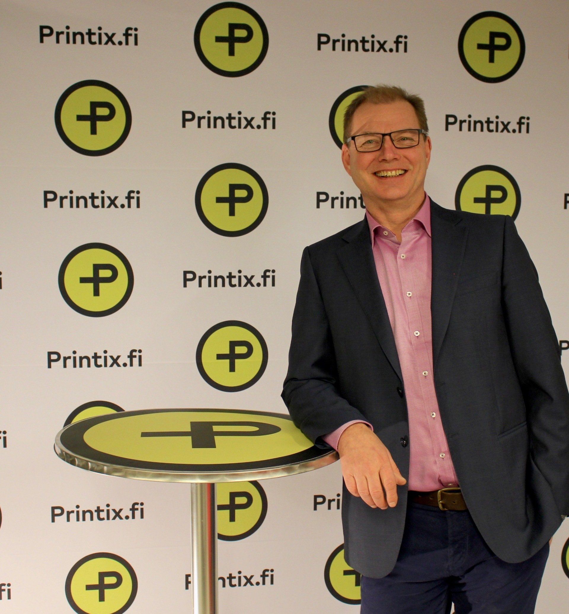 valokuva mies nojaa pystypöytään jossa logotarra