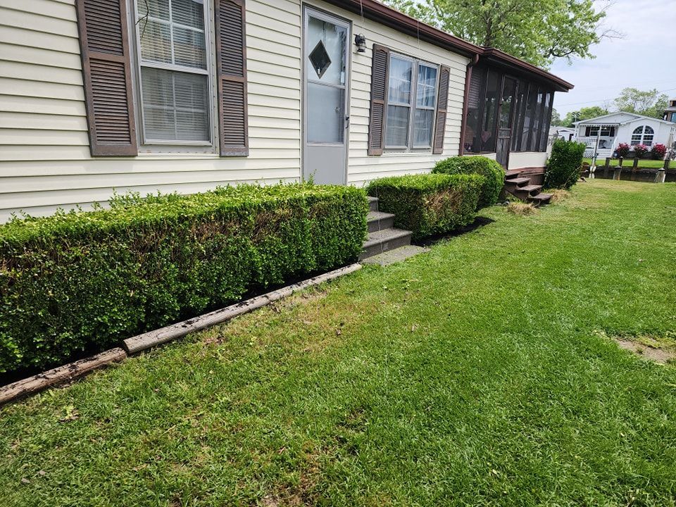 A mobile home with a lush green lawn in front of it.