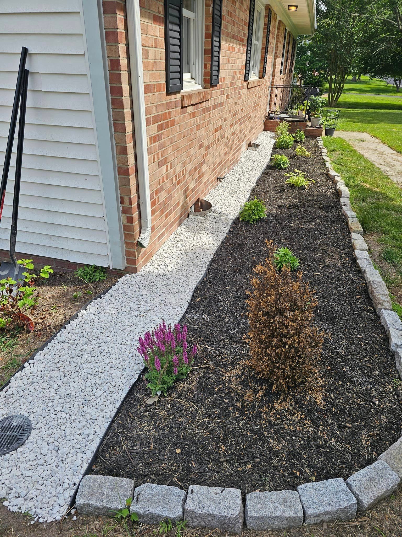 A brick house with a walkway and a garden in front of it.