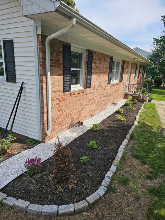 A house with purple and pink flowers in front of it