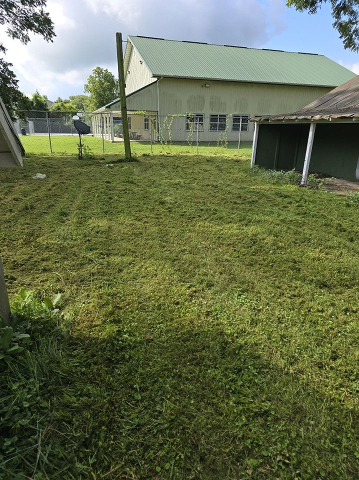 A large grassy field with a building in the background.