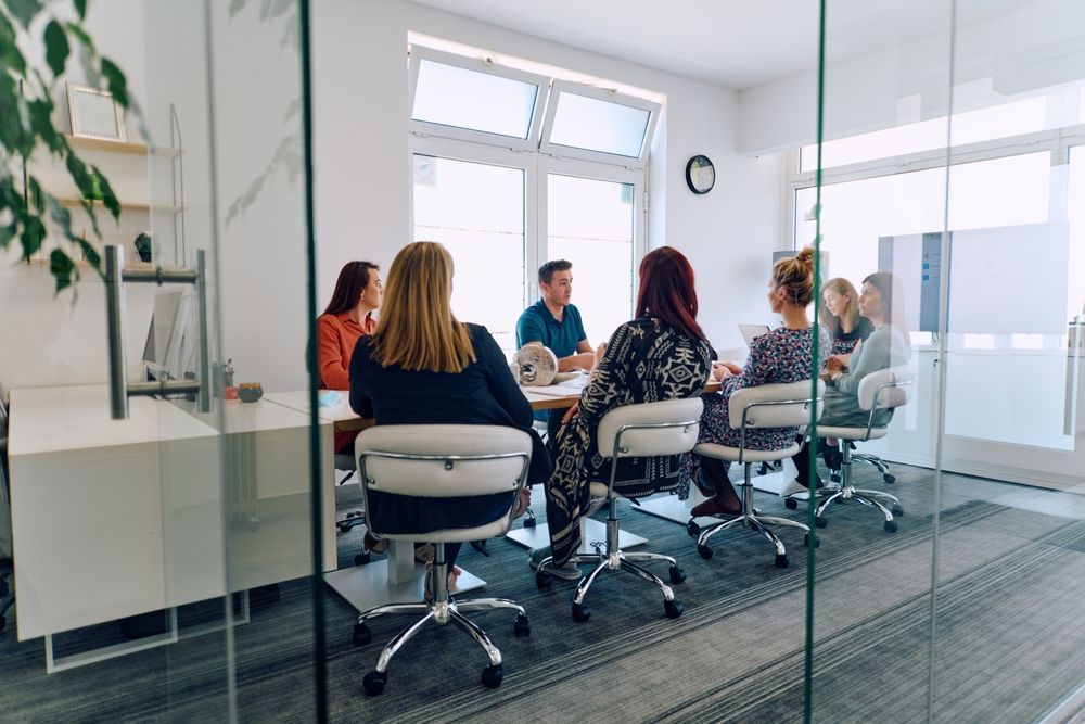 A group of people are sitting around a table in a conference room.