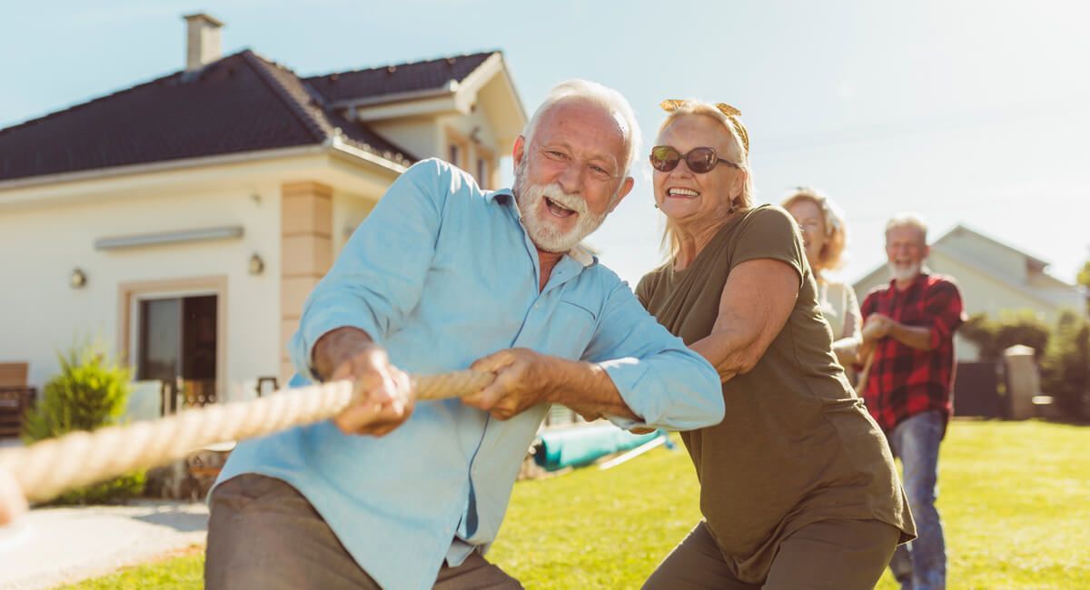 an elderly man and woman in a tug of war game