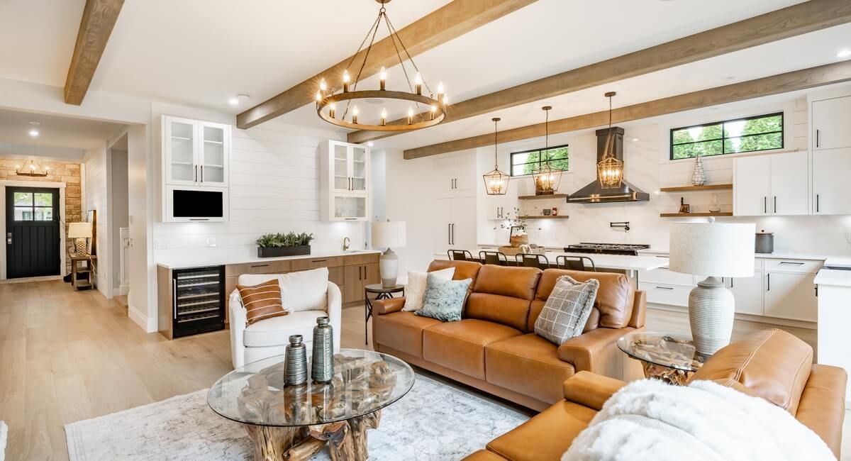 A living room with a brown couch and a glass coffee table.