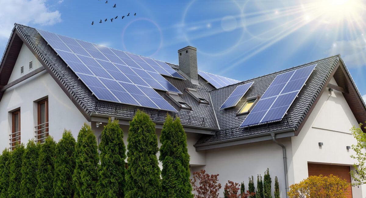 A white house with solar panels on the roof.