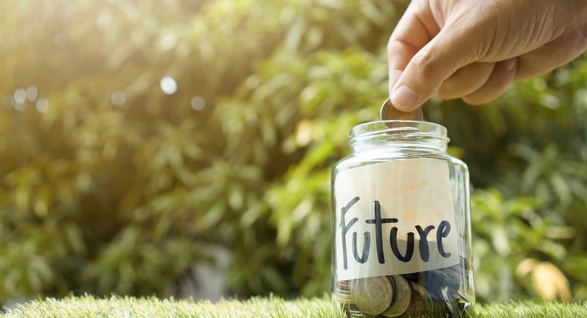 A person is putting a coin into a jar that says future.