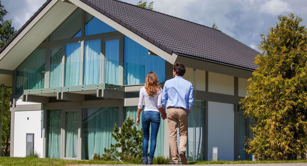 A man and a woman are walking towards a house.