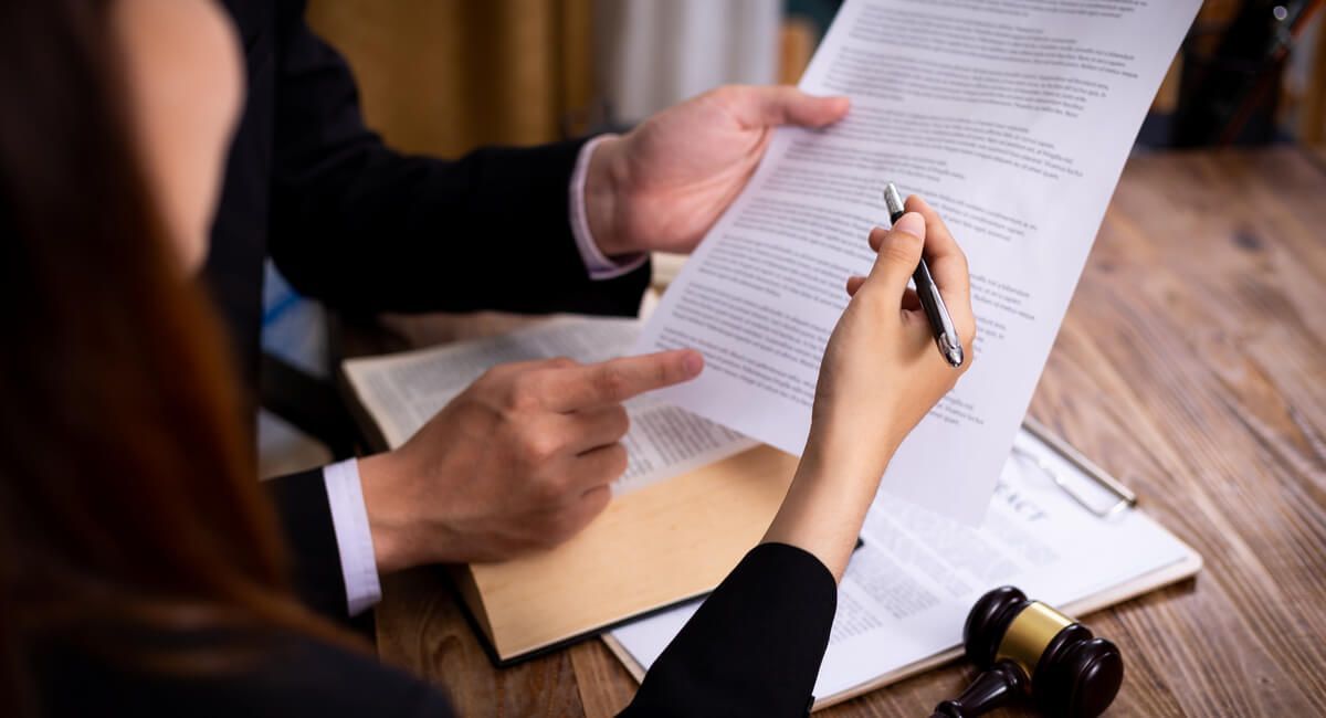 A man and a woman are sitting at a table looking at a piece of paper.