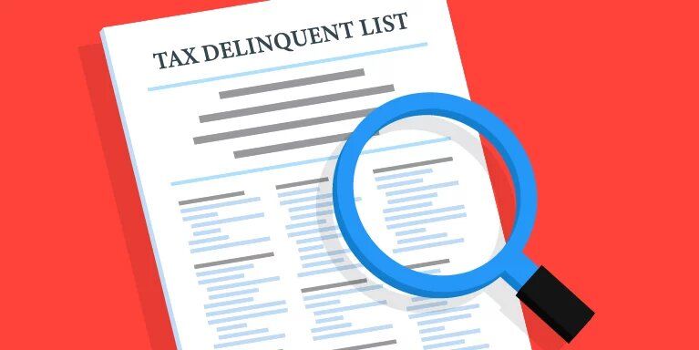 A magnifying glass is sitting on top of a tax delinquent list.