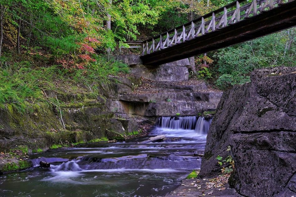 A bridge over a river with a waterfall in the background.