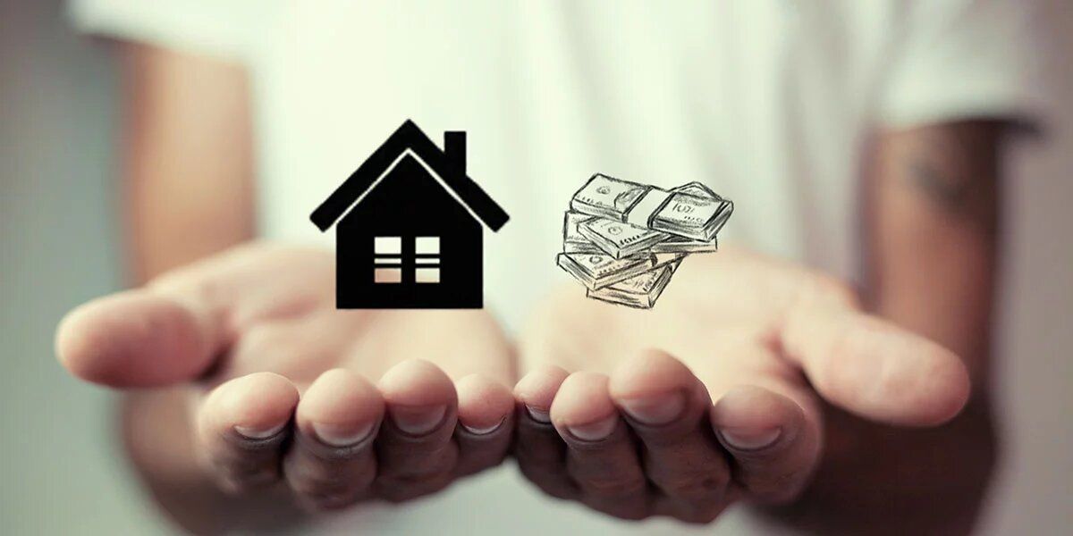 A person is holding a house and a pile of money in their hands.