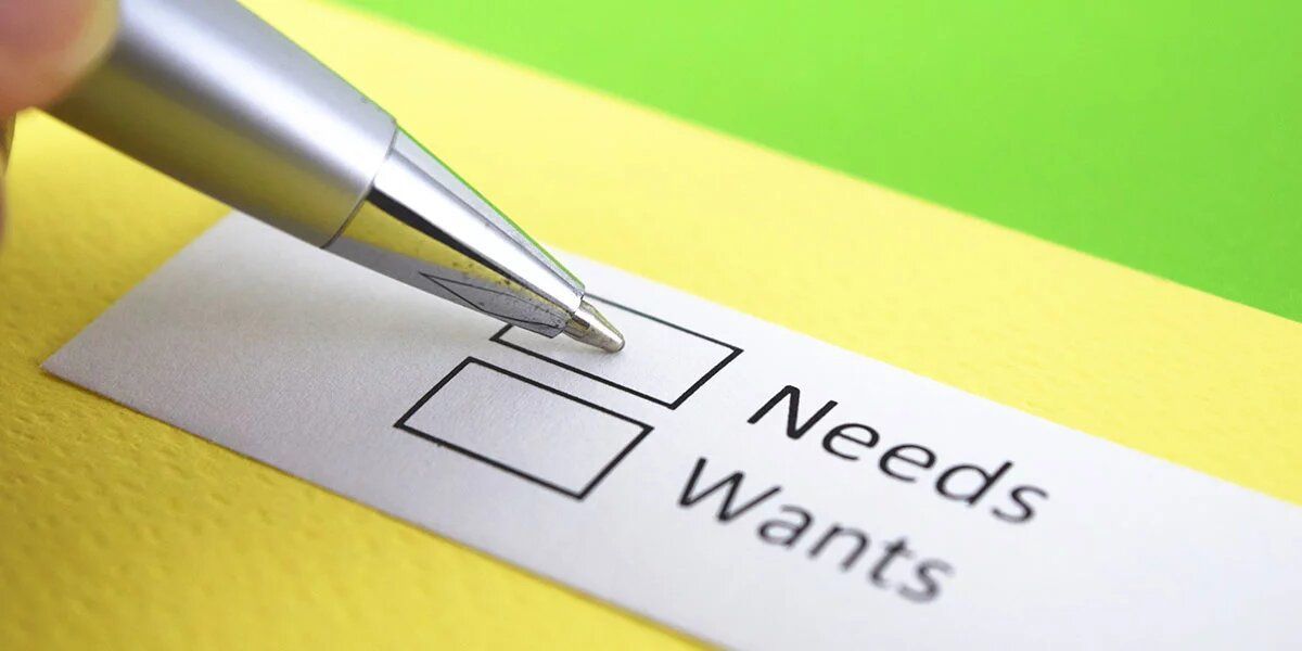 A person is filling out a needs and wants form with a pen