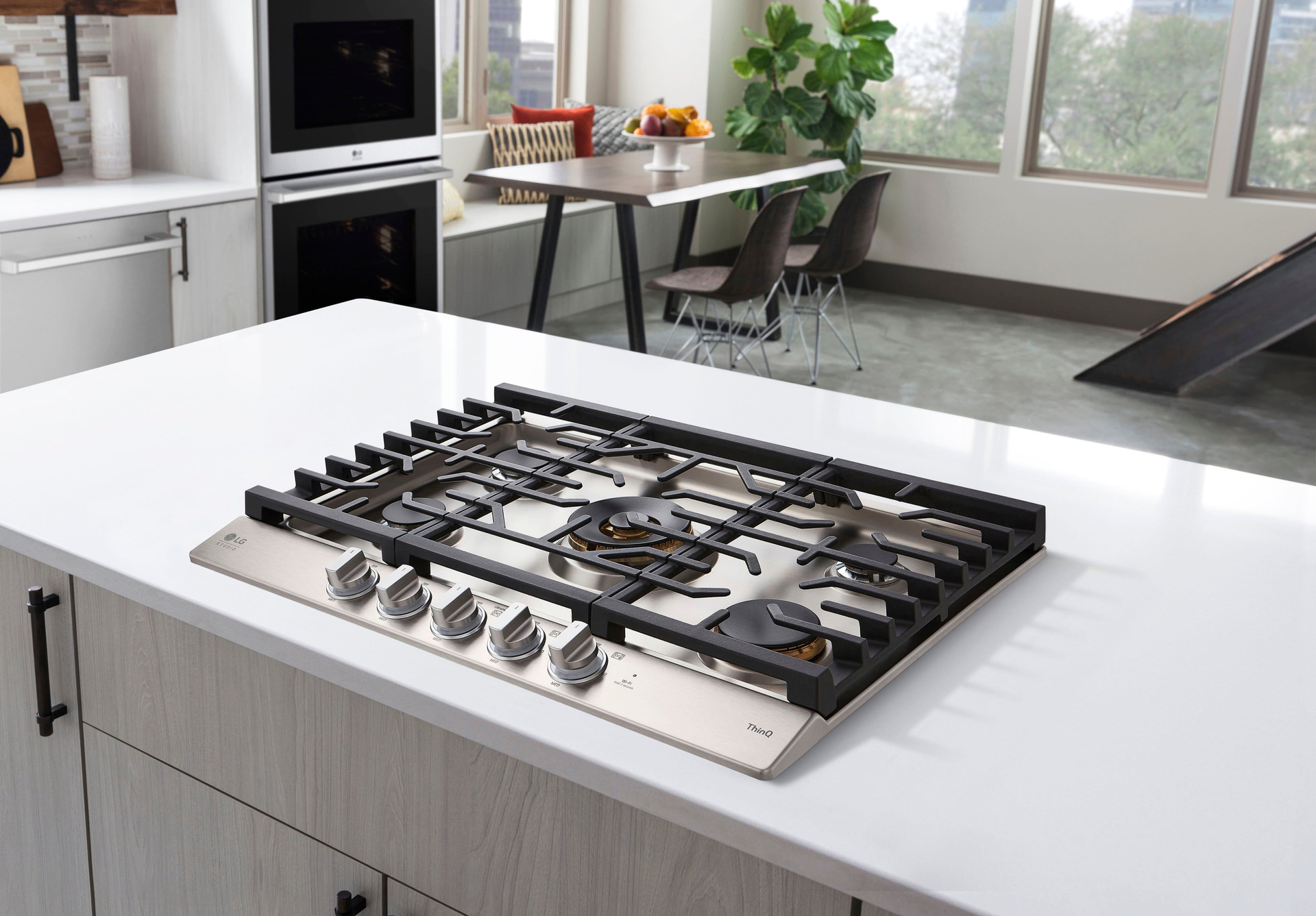 Stainless steel gas cooktop on white countertop in a modern kitchen.