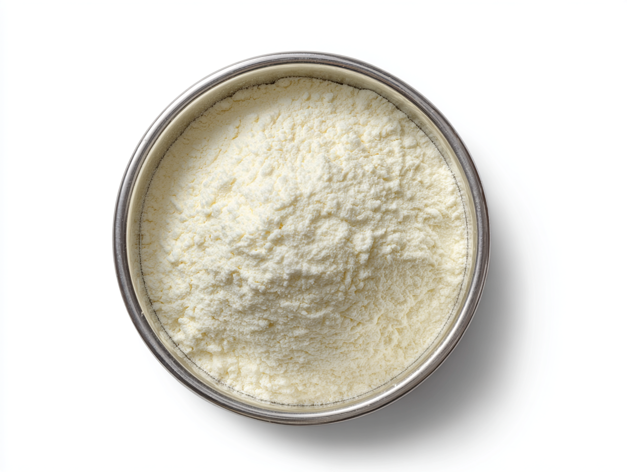 Overhead view of a round, silver container filled with a light-colored powder, possibly milk or a similar product.