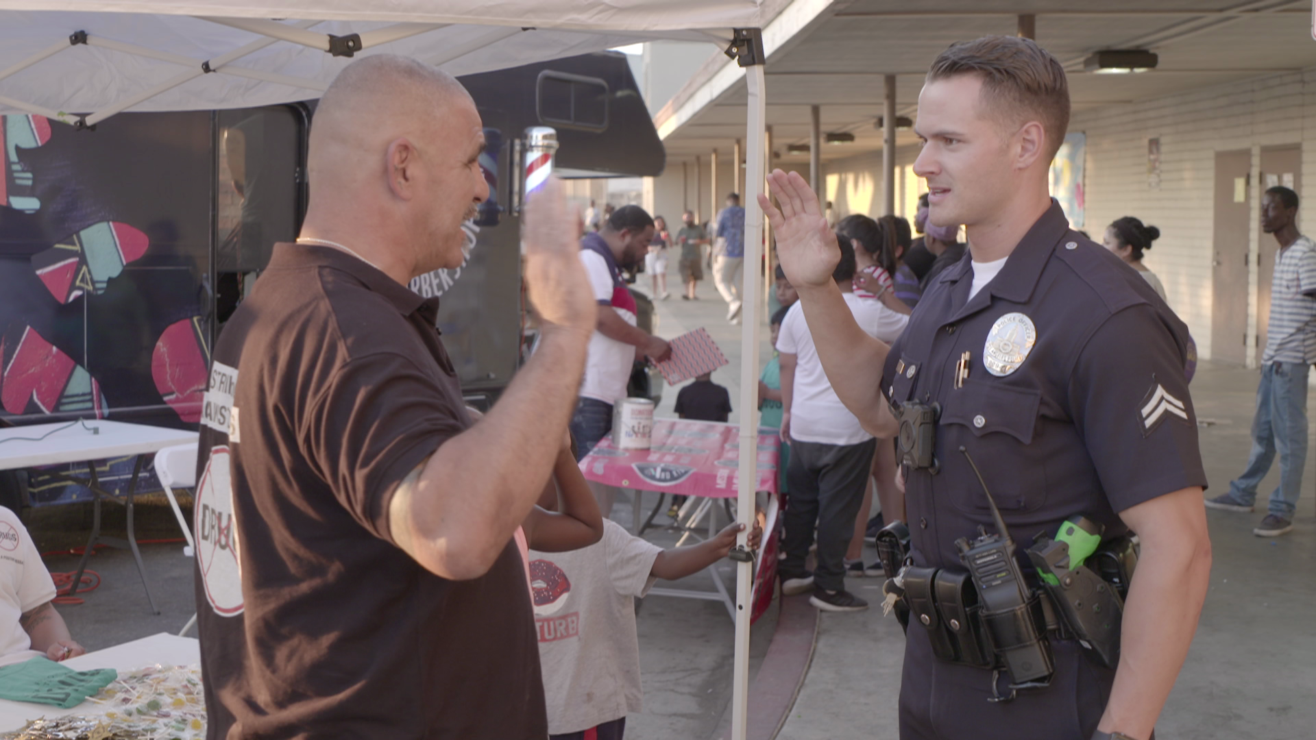 A man is giving a high five to a police officer.