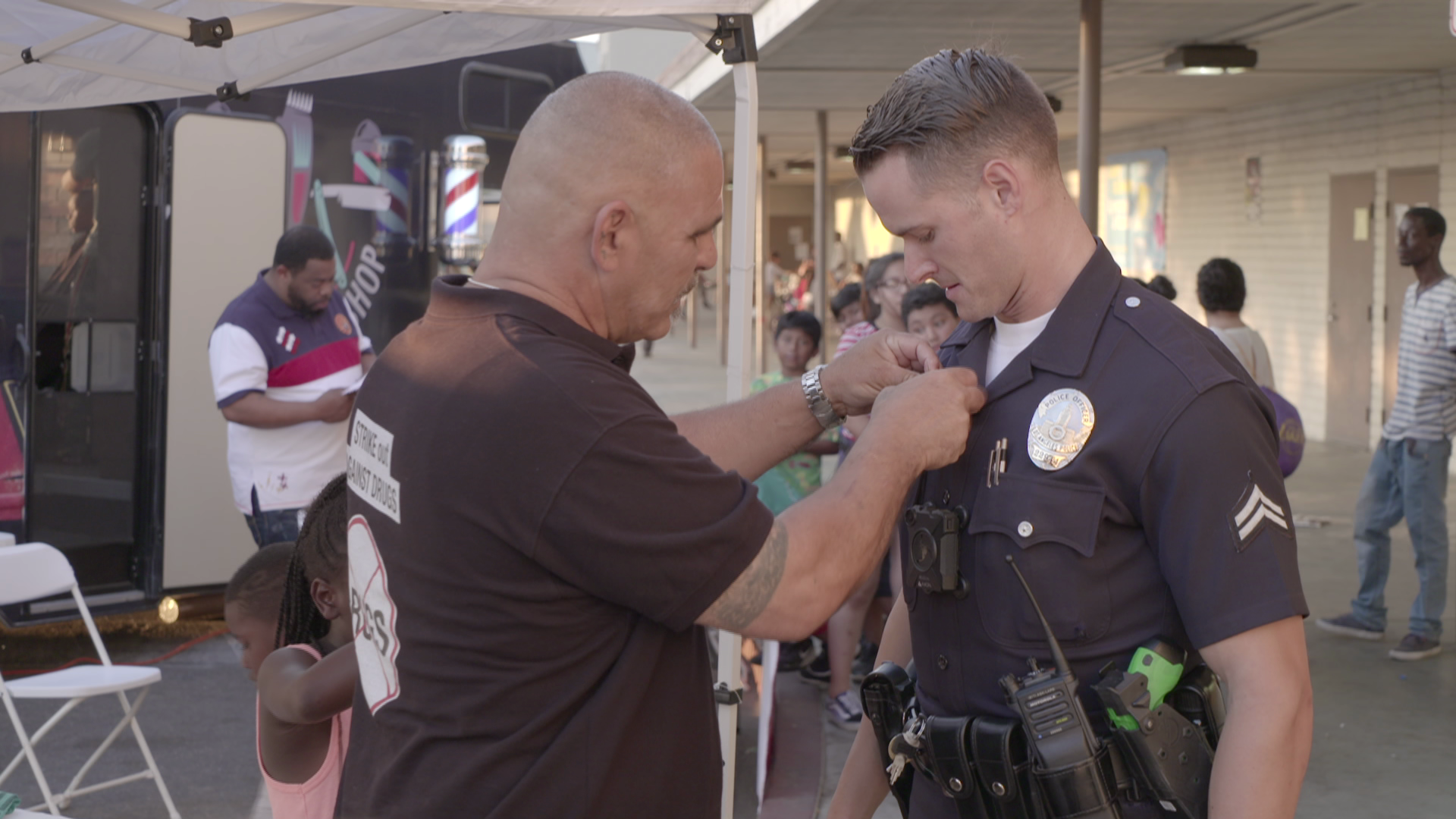 A man is putting a medal on a police officer 's chest.