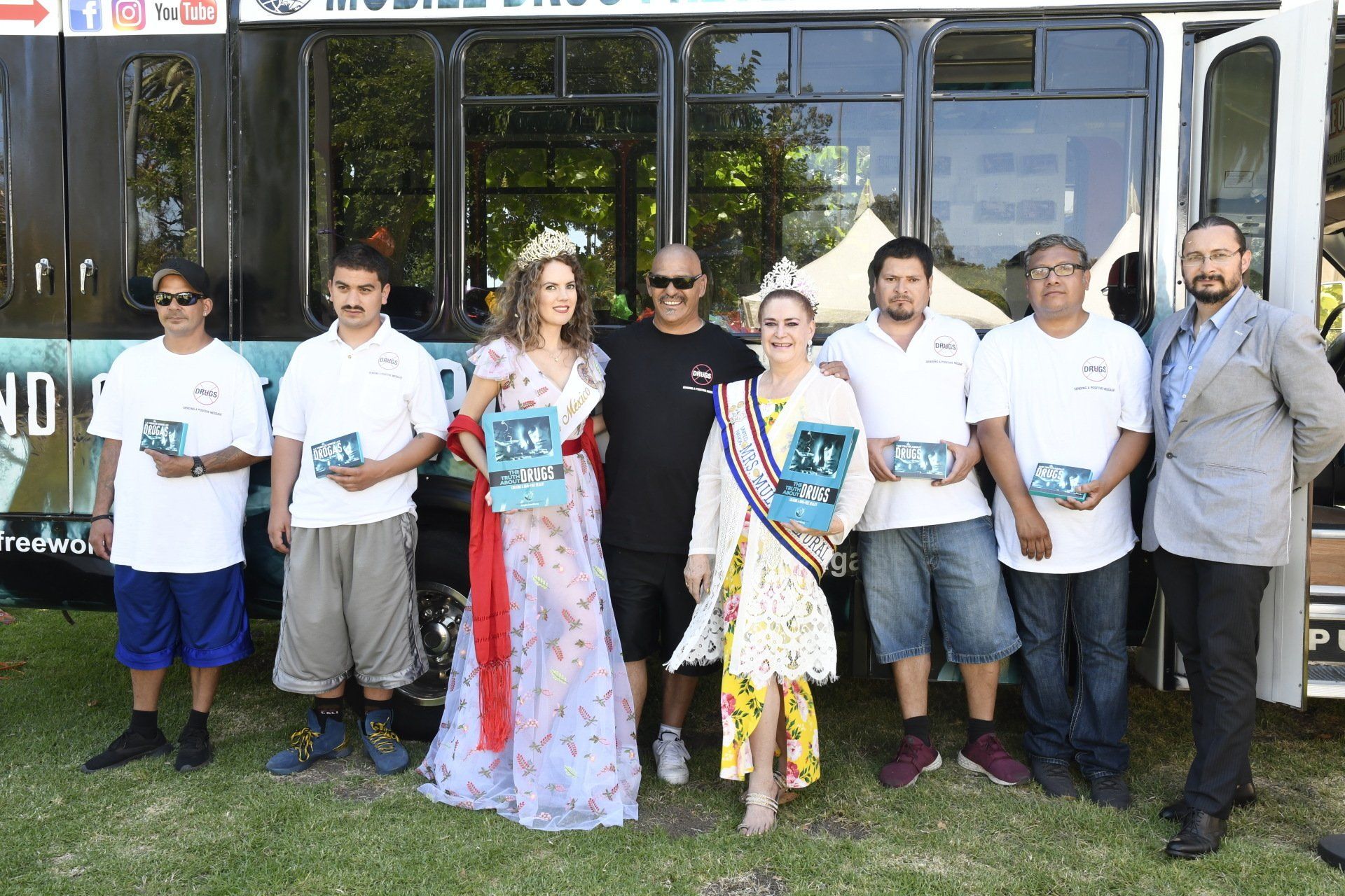 A group of people are posing for a picture in front of a bus.