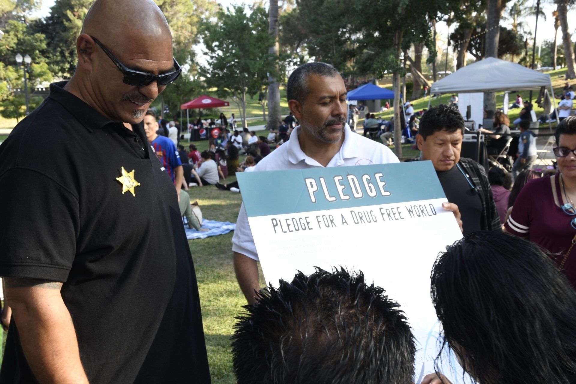 A man is holding a sign that says pledge