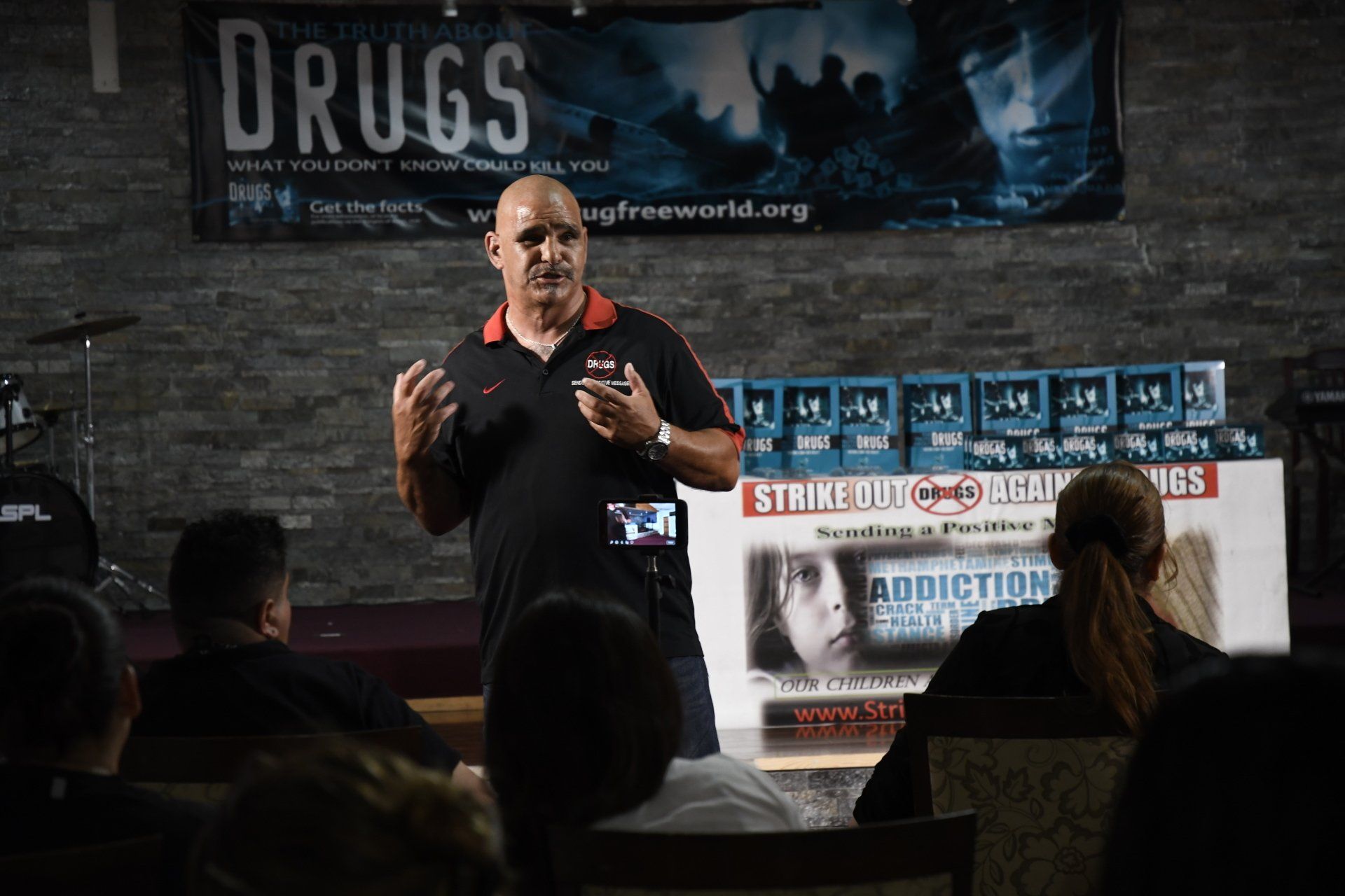 A man is giving a speech in front of a group of people.