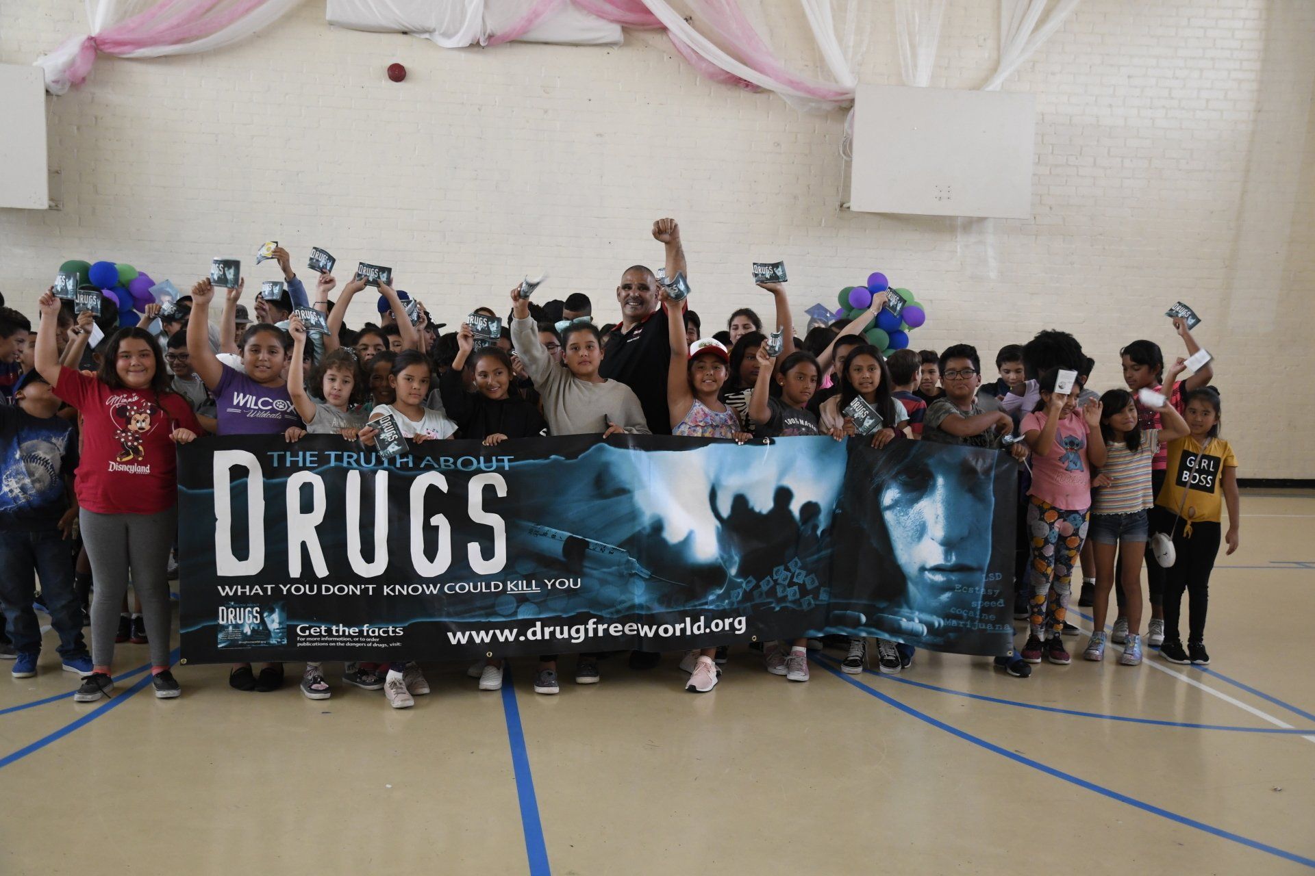 A group of people holding a sign that says drugs