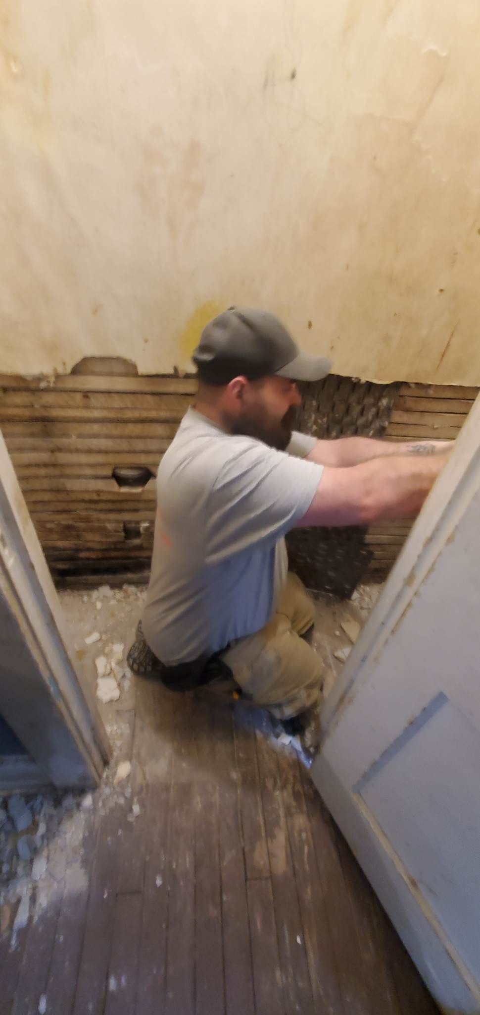 A man is kneeling on the floor in a room.