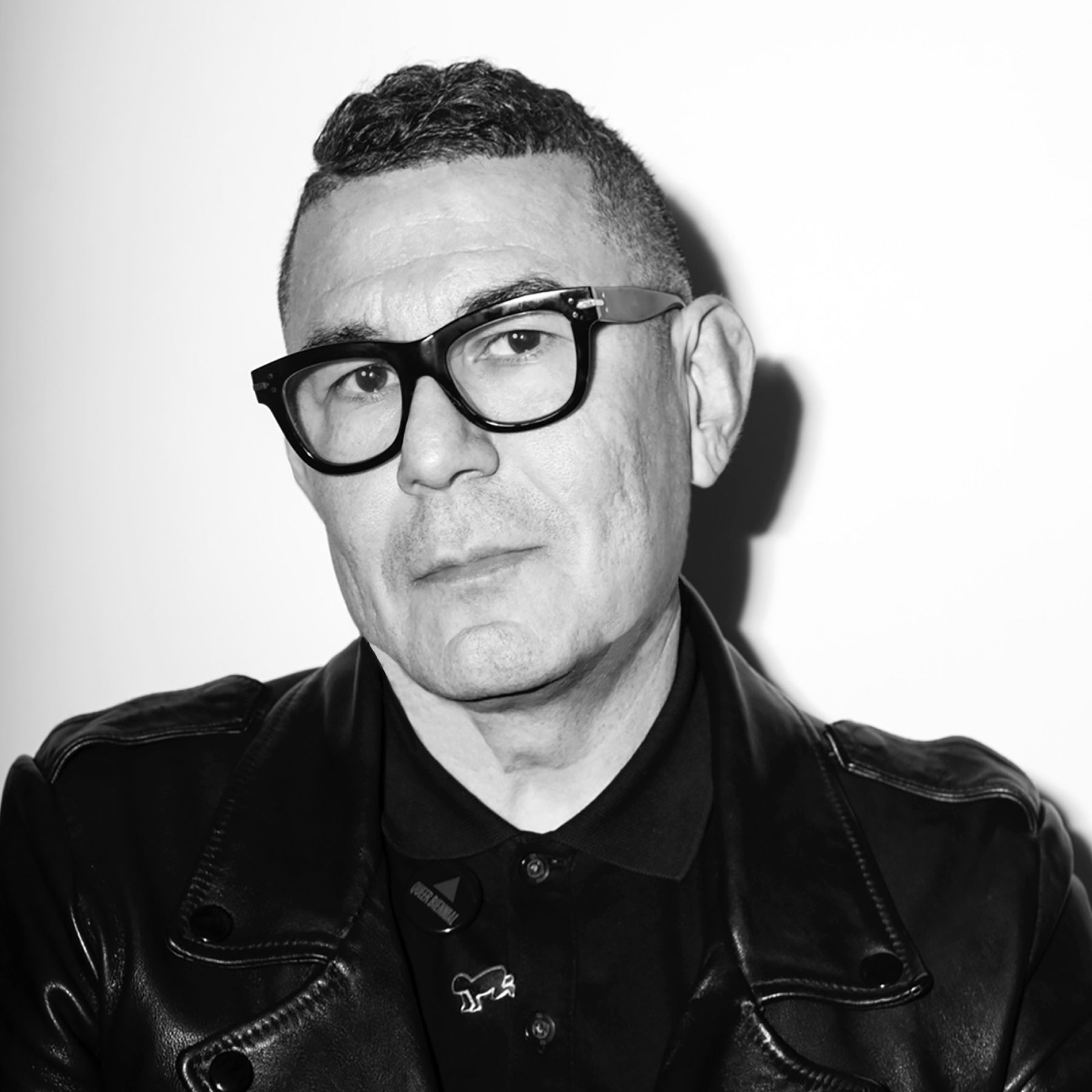 Black-and-white portrait of a person in glasses and a leather jacket, looking slightly to the side