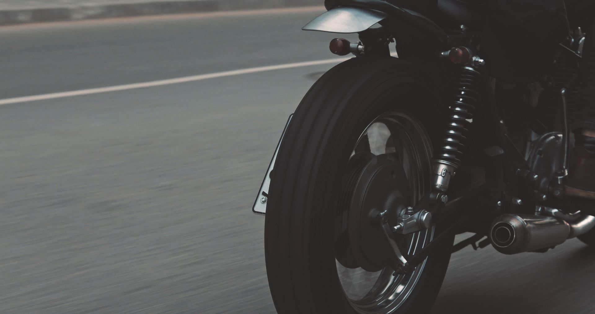 A close up of a motorcycle driving down a road.