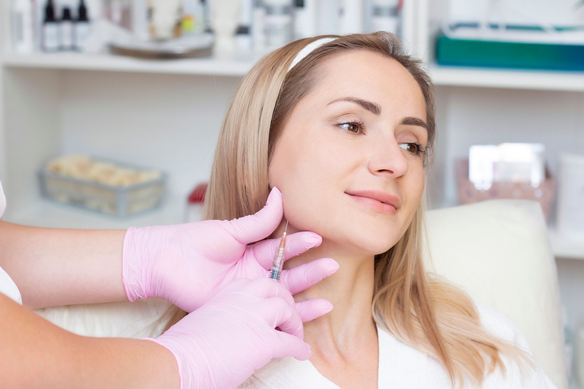 A woman is getting a botox injection in her neck.